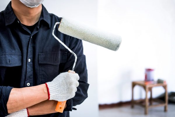 male-painter-with-arm-crossed-holding-paint-roller-scaled.jpg
